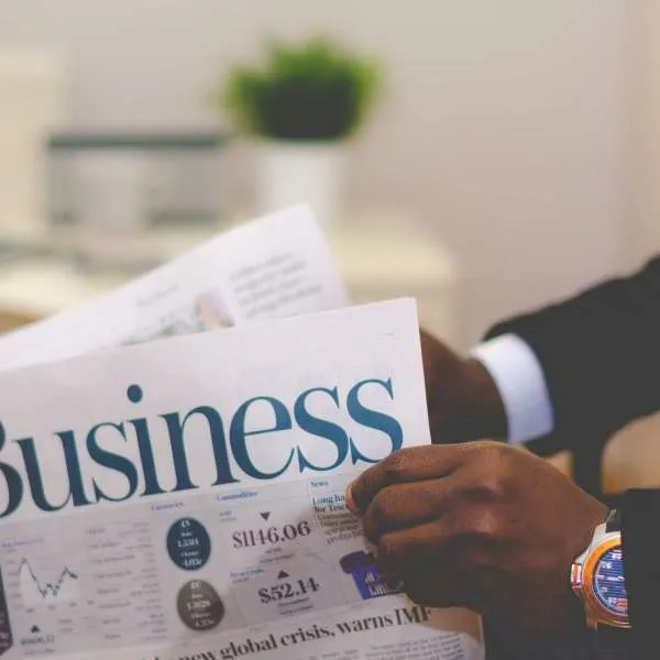 Person reading the business section of a newspaper