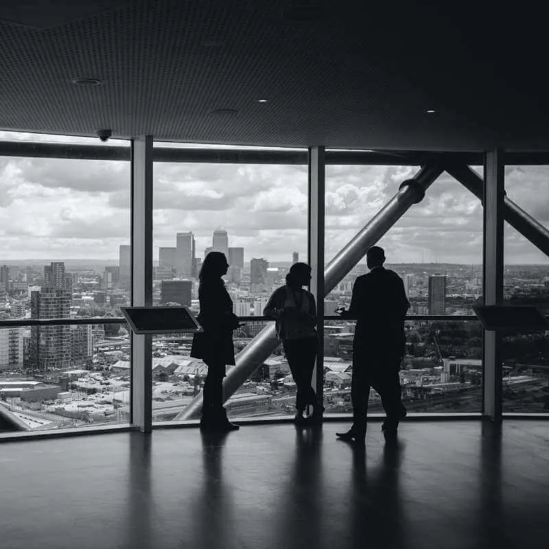 Business team looking out over a city skyline from an office window